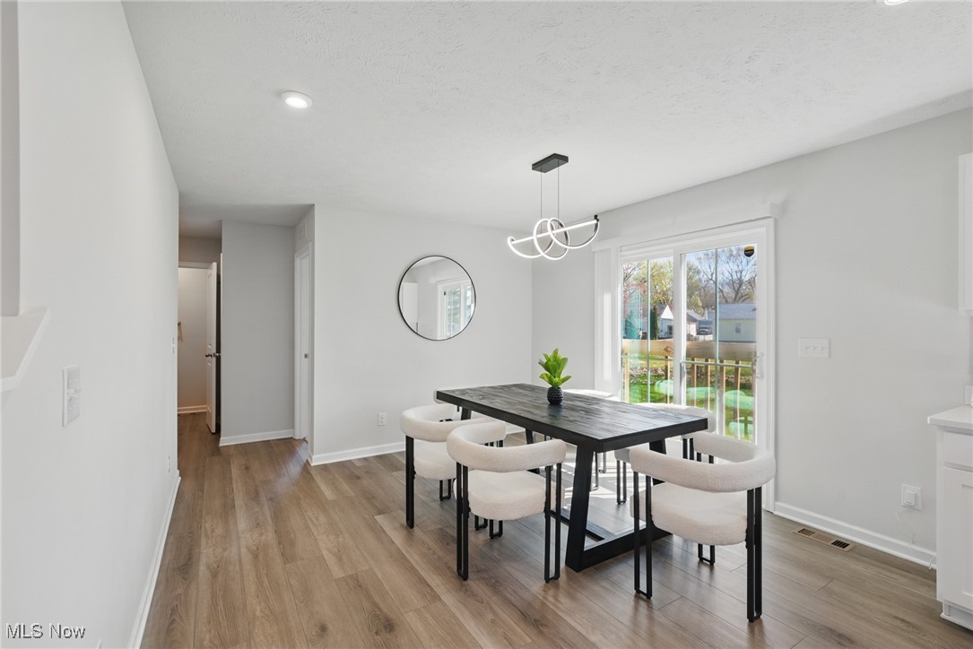 Dining room with a dark table, upholstered chairs, and sliding glass doors to the backyard.