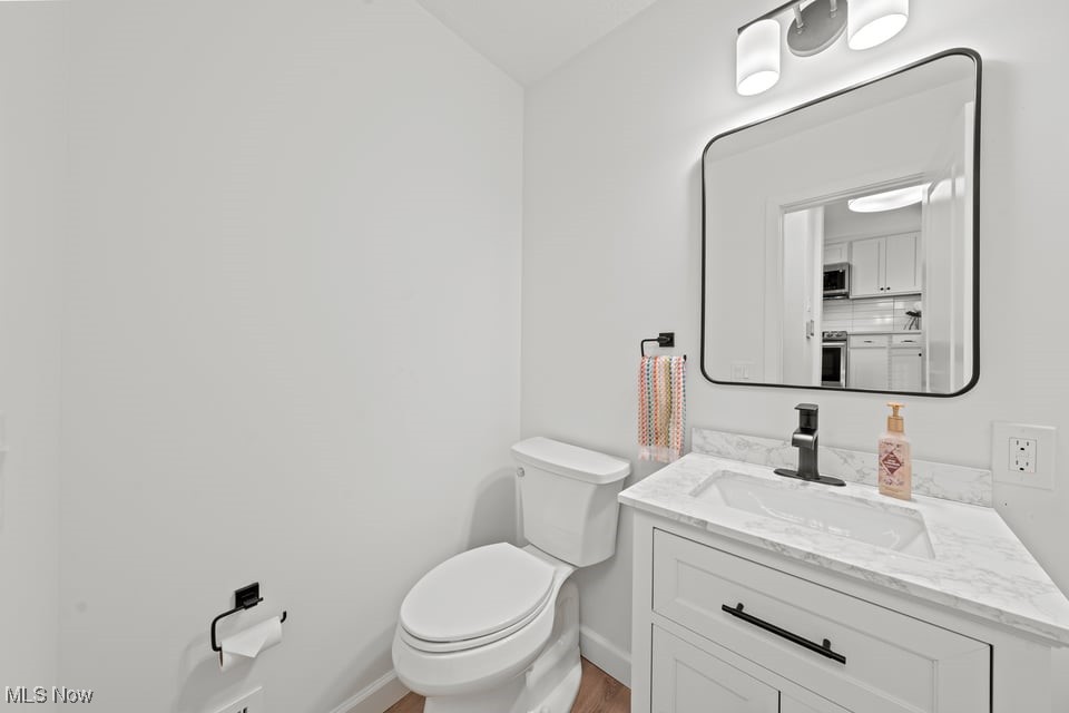 Bathroom with a marble-look vanity, black faucet, framed mirror, and colorful hand towels.