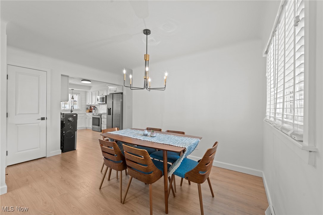 Dining room with a blue runner and wooden table beside an open kitchen.