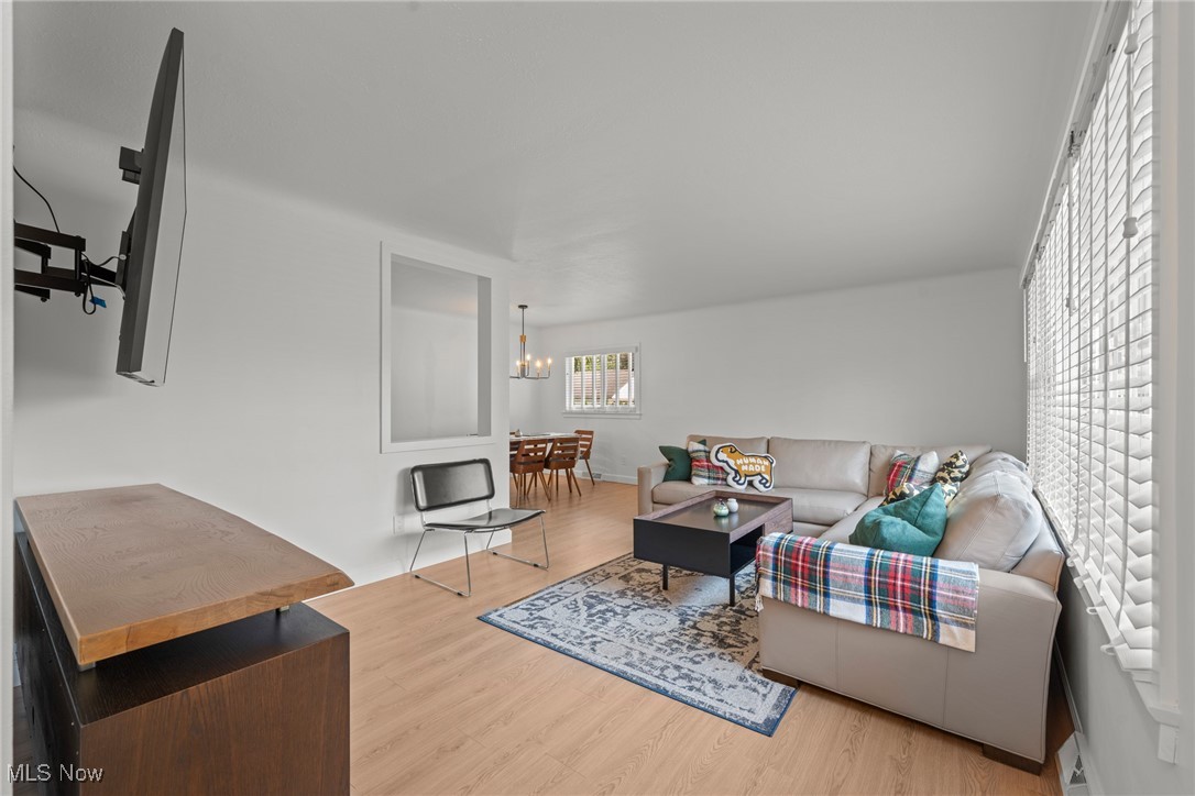 Living room with a white sectional, patterned rug, and dining area beyond.