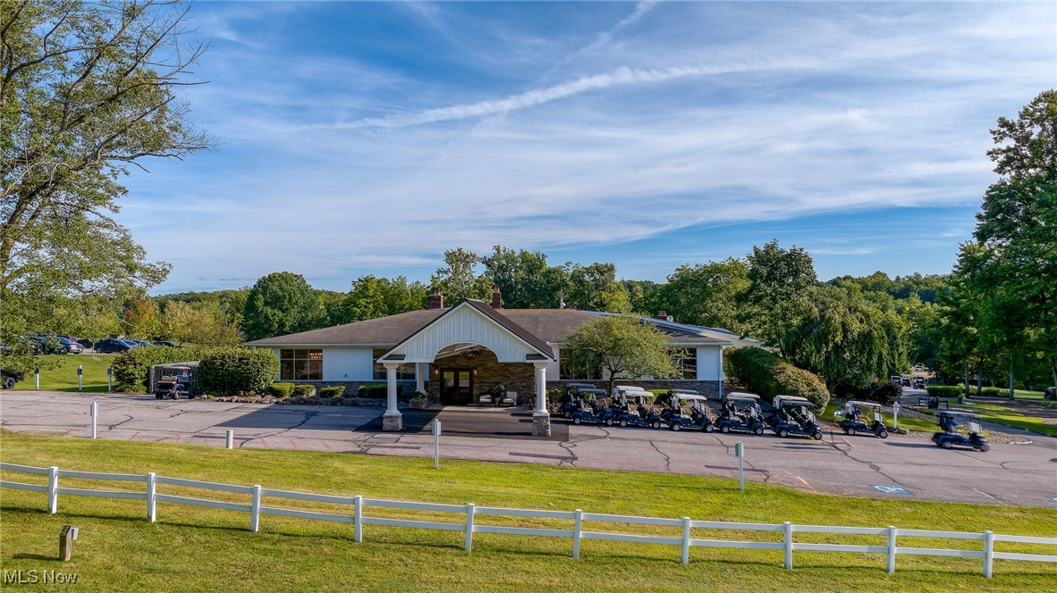 Clubhouse with a covered entrance and golf carts lined up in front
