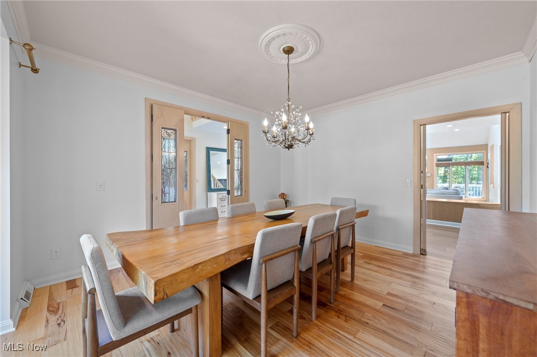 Dining room with a live-edge wood table, upholstered chairs, and chandelier.