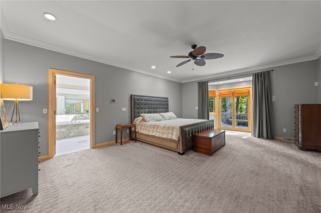 Primary bedroom with a tufted bed and glass doors opening to a balcony.
