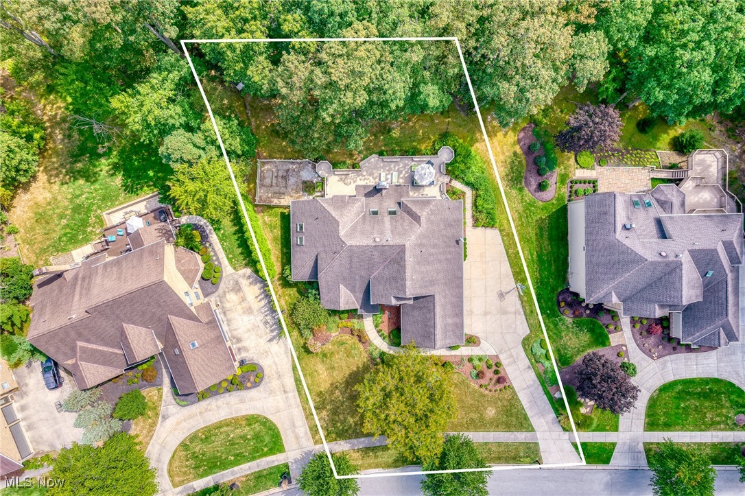 Aerial view of 8532 Timber Trail, with the property outlined in white among mature trees and neighboring homes.