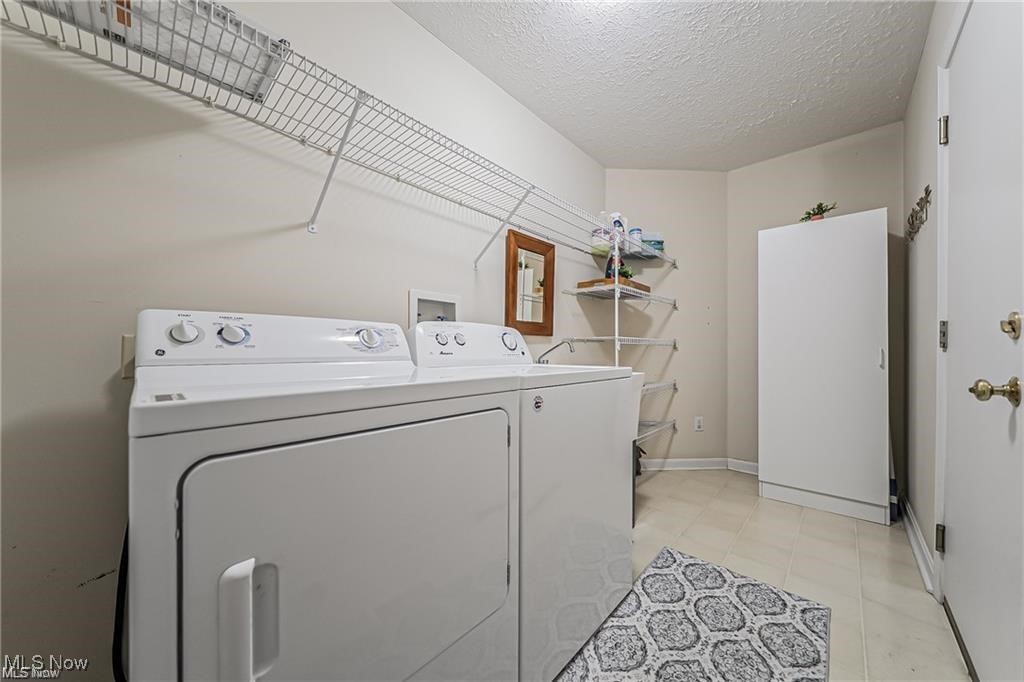 Laundry room with white washer and dryer beneath wall-mounted wire shelving.