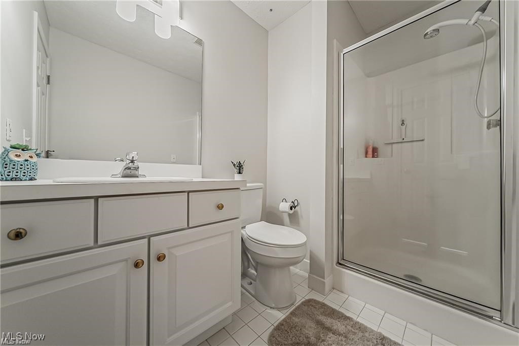 Bathroom with a white paneled vanity, large mirror, and glass-enclosed shower.