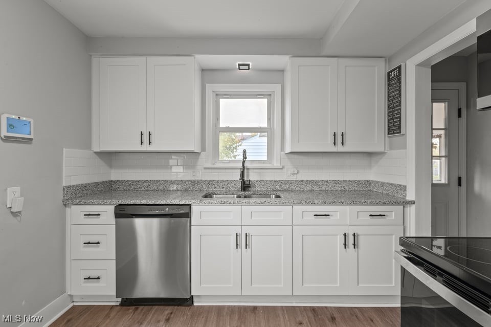 Kitchen with white shaker cabinets, granite counters, subway tile backsplash, and a window above the sink.