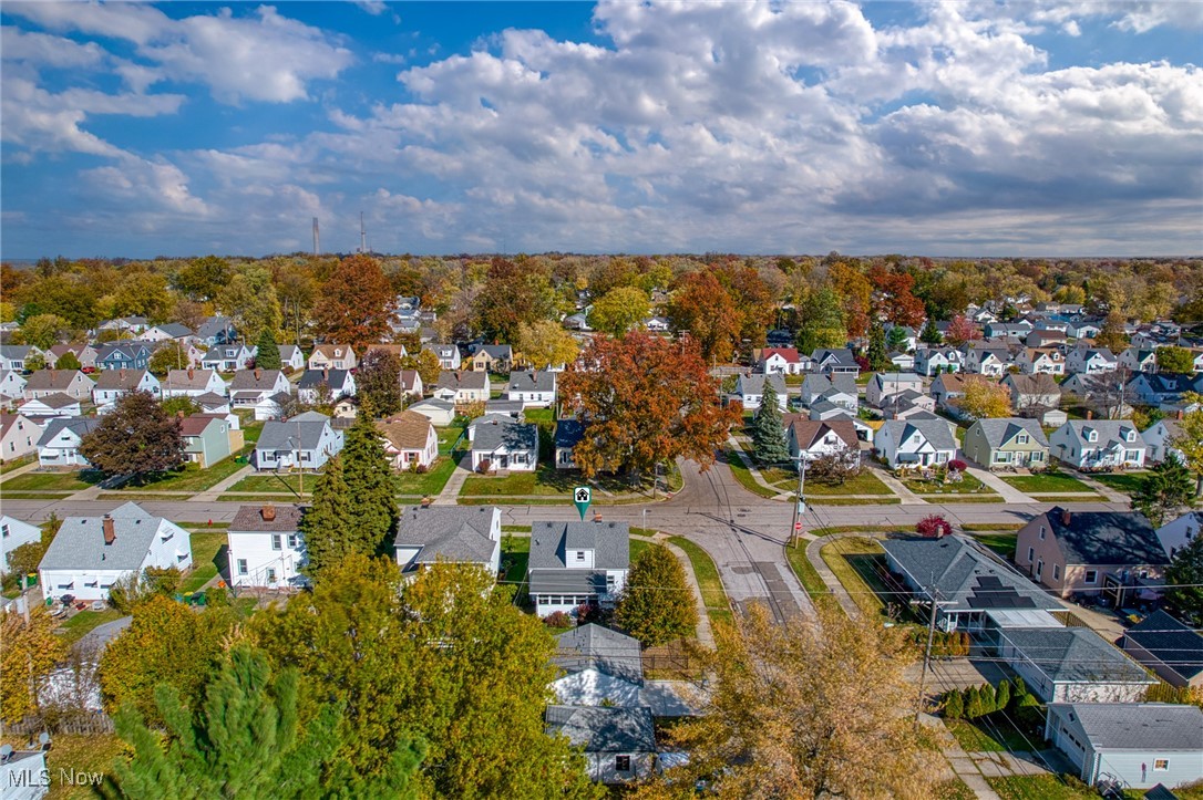 Aerial view of a residential neighborhood with autumn foliage and a marked street corner.