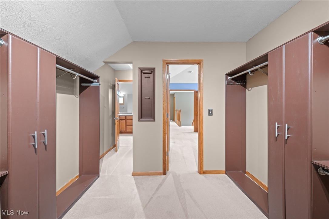 Walk-in dressing room with built-in wardrobes and hanging rails along both sides.