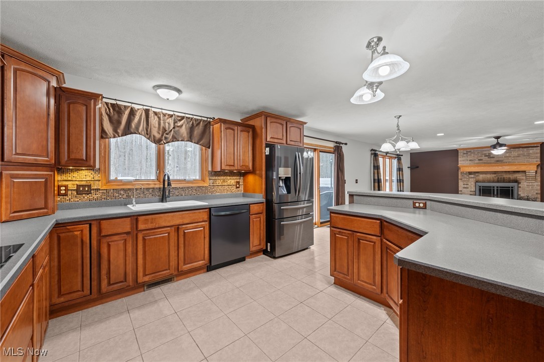 Kitchen with warm wood cabinets, stainless steel appliances, and a large gray countertop island.