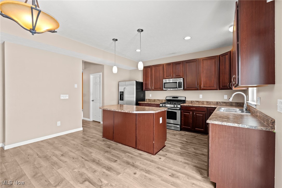 Kitchen with dark wood cabinets, stainless steel appliances, and a central island.