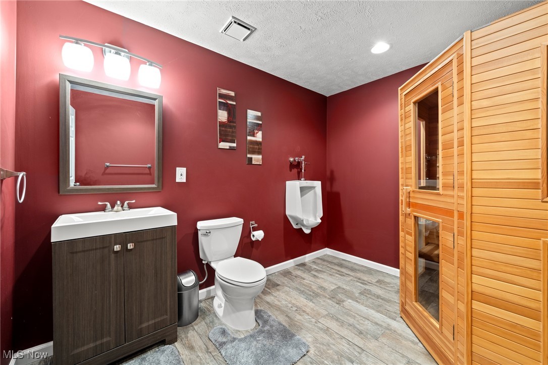 Bathroom with red walls, dark wood vanity, and a large wooden sauna.