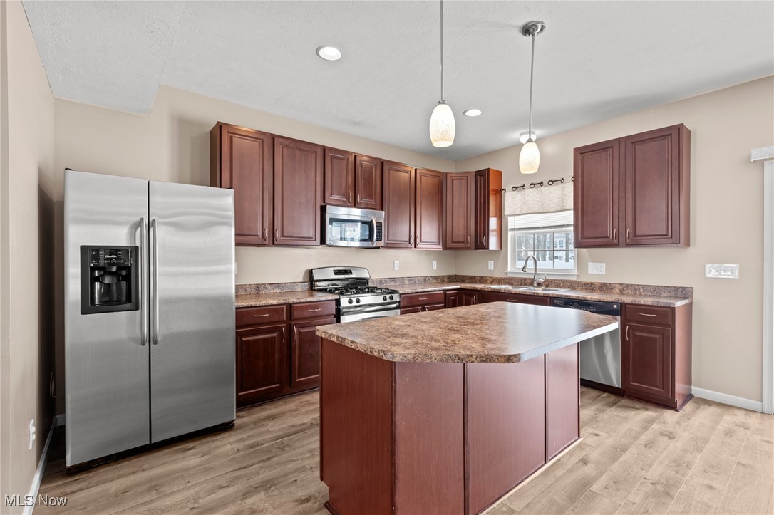 Kitchen with cherry cabinets, stainless steel appliances, and a large central island.