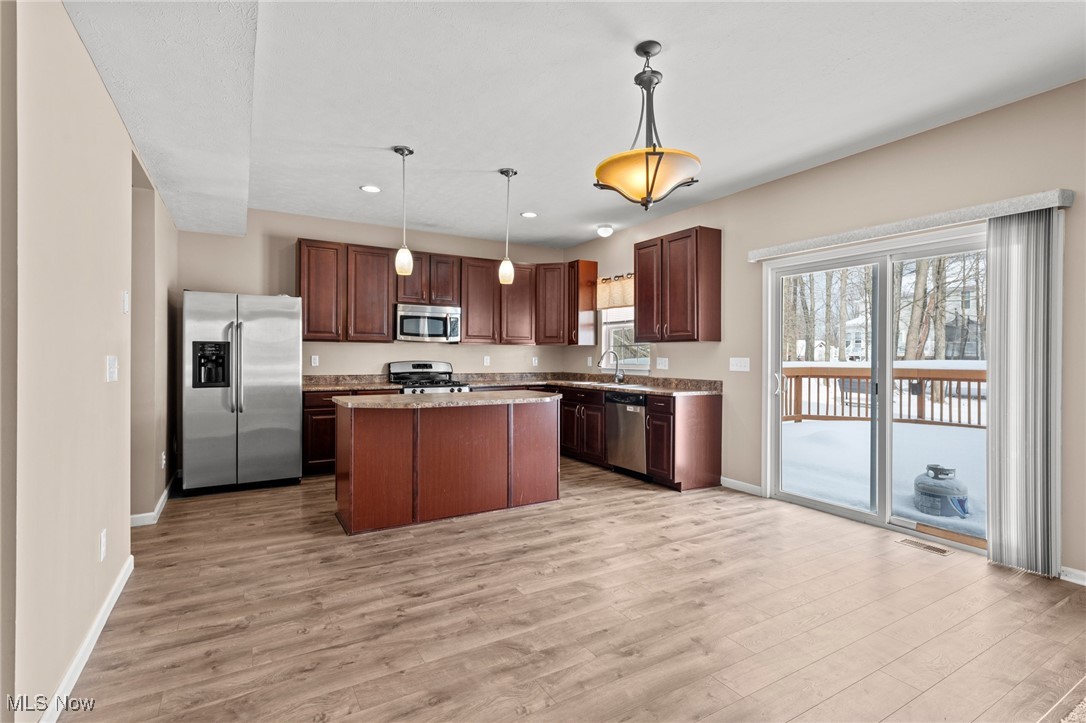 Kitchen with a central island and sliding doors opening to a snow-covered deck.