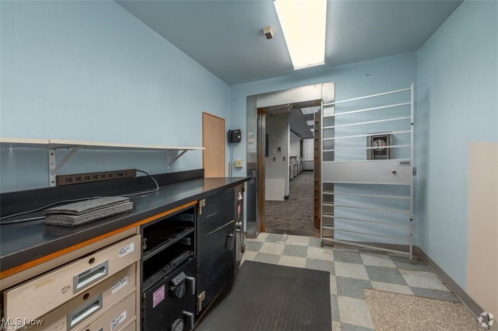 Interior room with a long counter, built-in equipment, and a metal security gate.