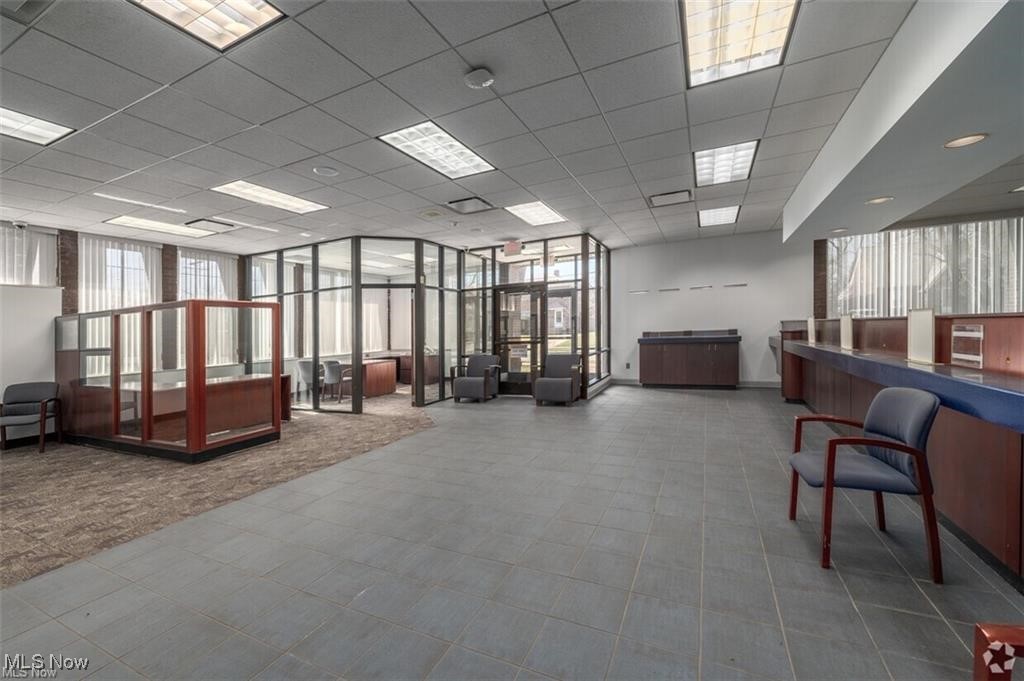 Commercial office interior with glass-partitioned work areas and reception counters.
