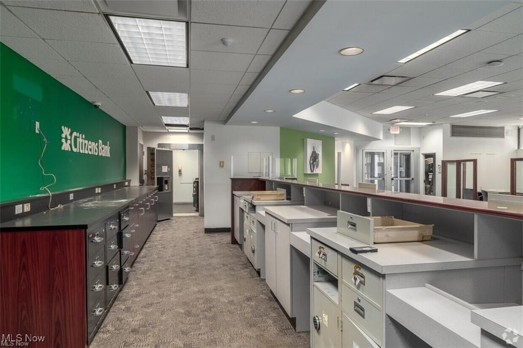Bank interior with a Citizens Bank sign, teller counters, carpeted floor, and fluorescent ceiling lights.