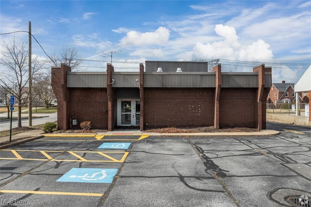 Single-story brick building with a centered entrance and accessible parking spaces in front.