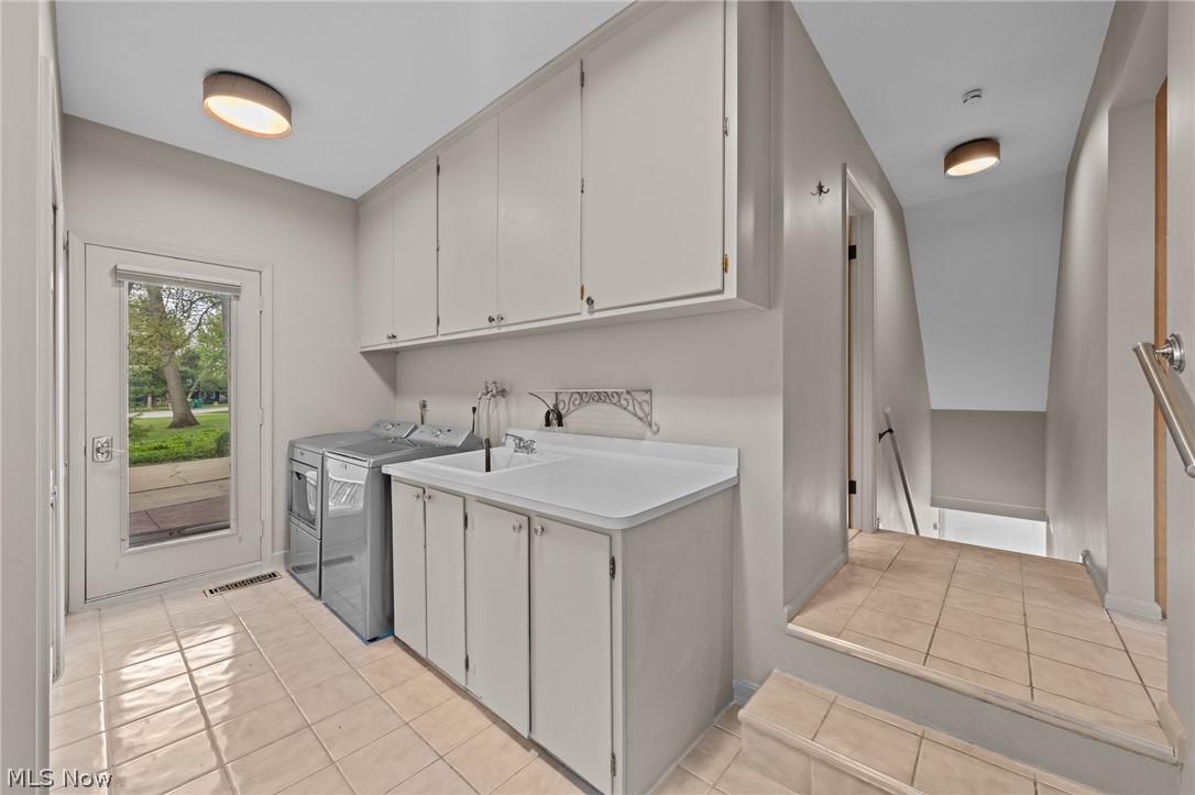 Laundry room with washer, dryer, utility sink, and a glass-paneled exterior door.