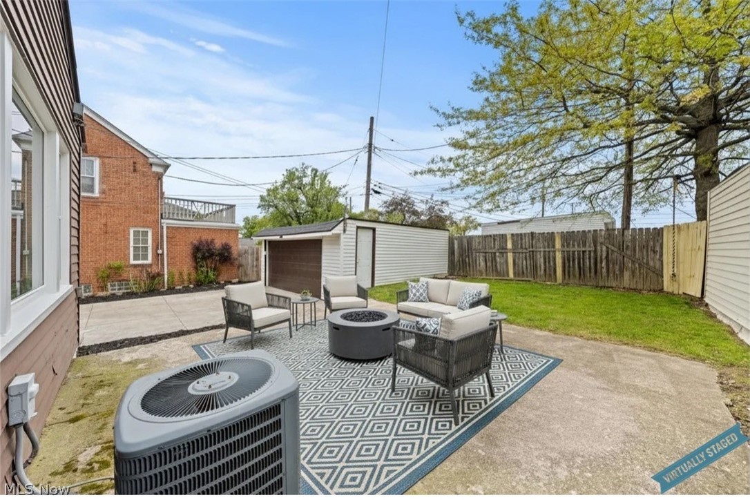 Backyard patio with outdoor seating, a fire pit, and a fenced lawn.