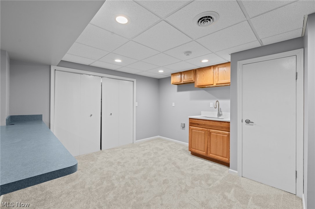 Unfurnished room with a sink, wooden cabinets, blue-gray counter, and sliding closet doors.
