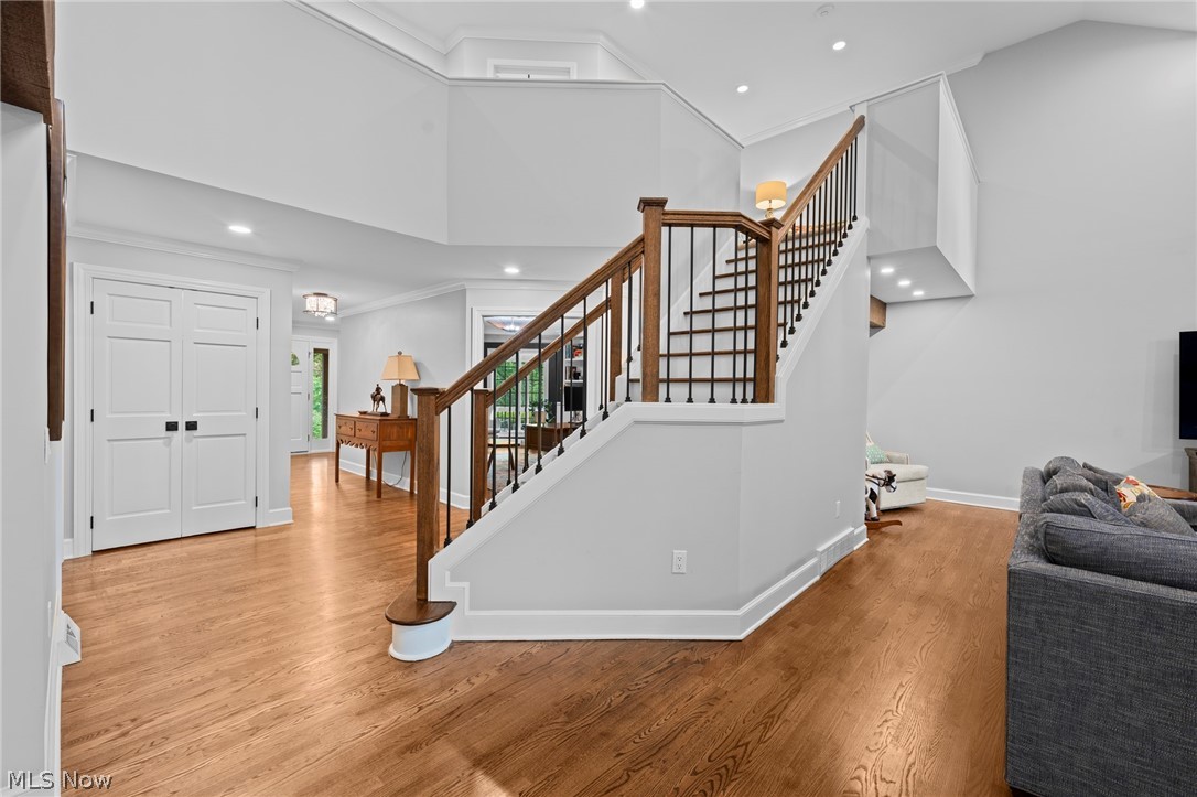 Two-story entry with a dark wood staircase, black balusters, and warm hardwood floors.