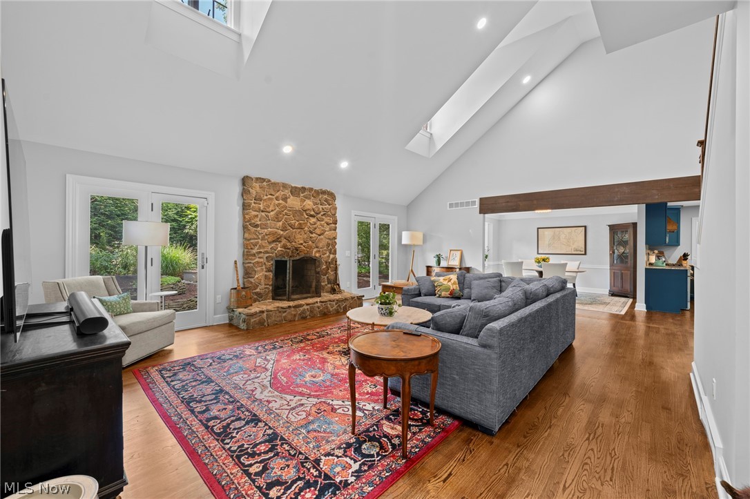 Living room with a stone fireplace, vaulted ceiling, gray sectional, and patterned rug.