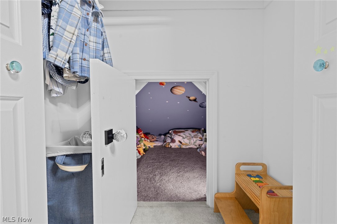 Child’s bedroom with a purple planet-themed ceiling, seen through an open closet doorway.