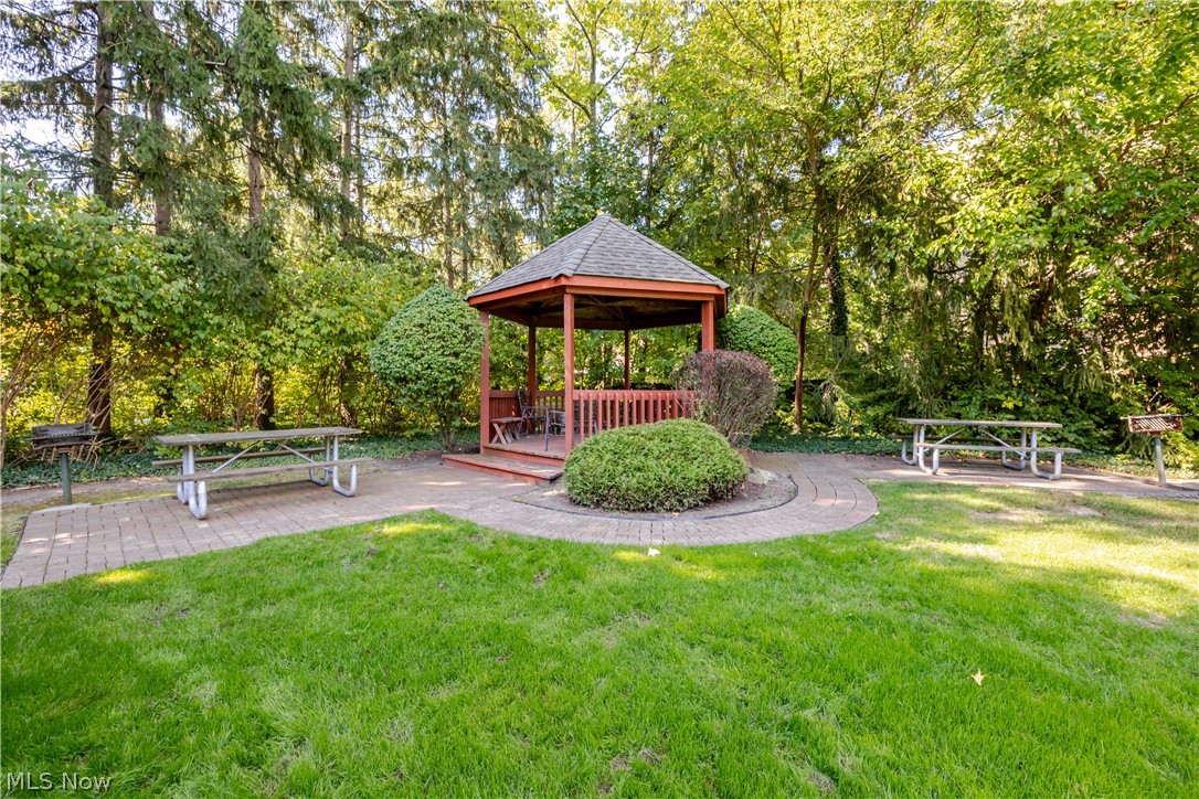 Landscaped picnic area with a wooden gazebo and picnic tables.