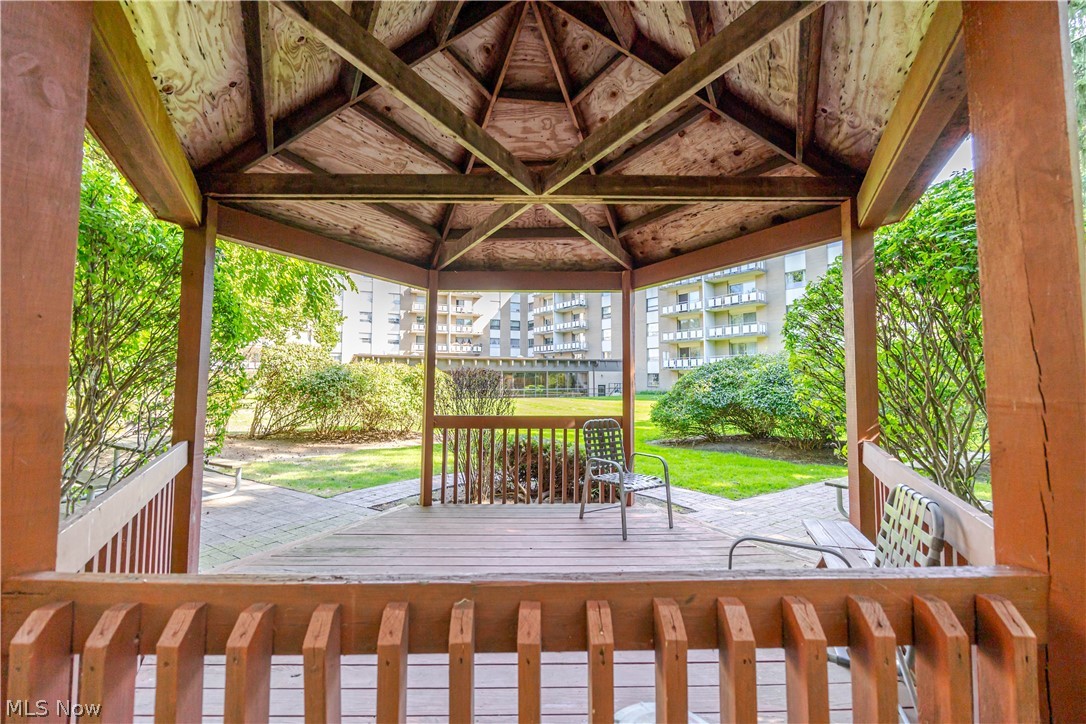 Wooden gazebo patio overlooking a landscaped courtyard and apartment balconies.