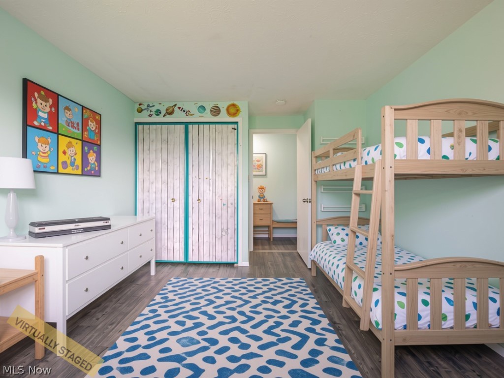 Bedroom with wooden bunk beds, mint walls, space-themed decor, and a blue patterned rug.