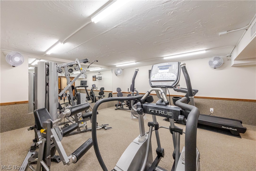 Fitness room with cardio machines, weight equipment, and a treadmill.