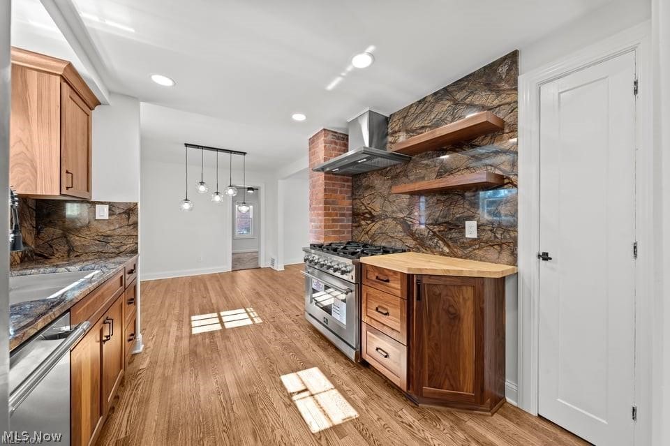 Kitchen with wood cabinets, hardwood floors, and a dramatic veined stone backsplash.