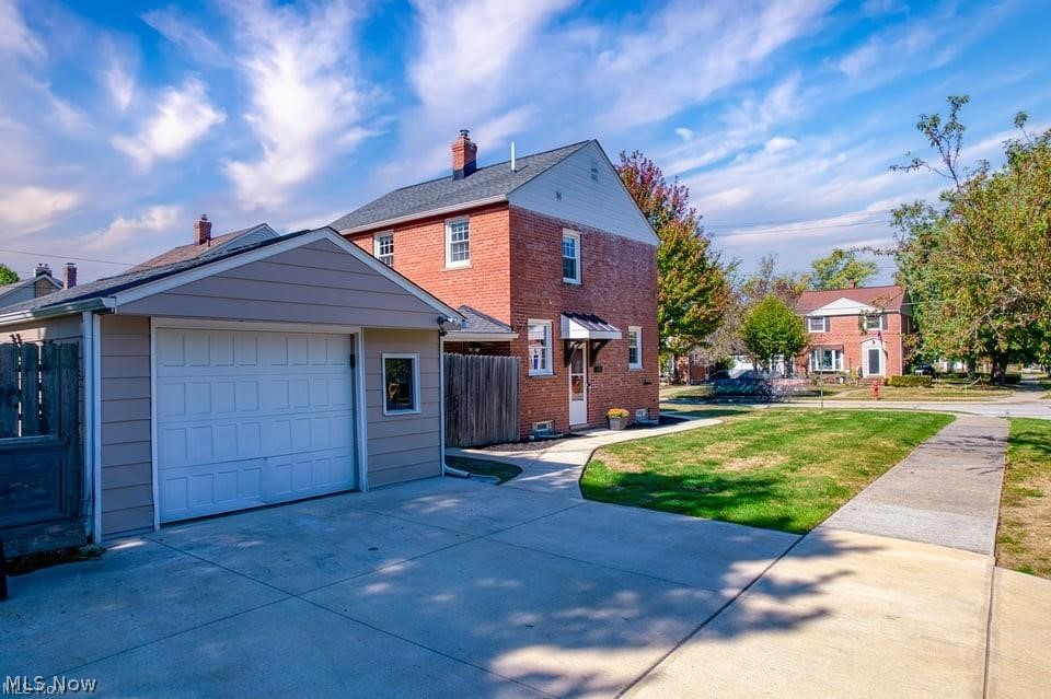 Two-story brick house with an attached gray garage and a wide concrete driveway.