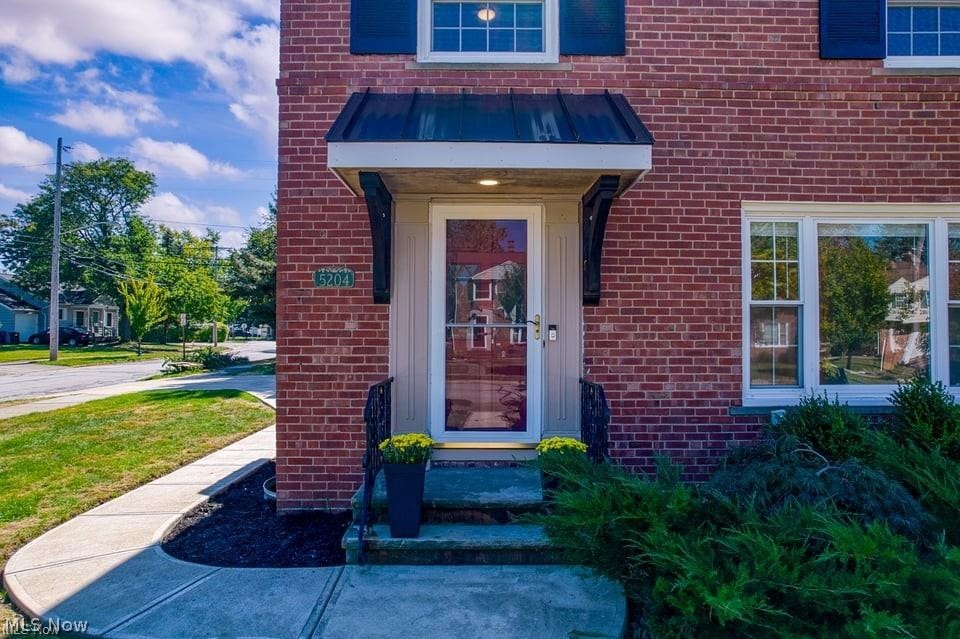 Brick home entrance with a covered awning, glass front door, and 5204 address plaque.