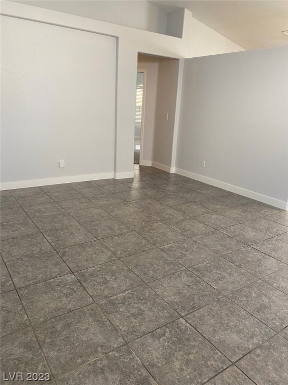 Empty room with gray tile flooring and an open doorway.