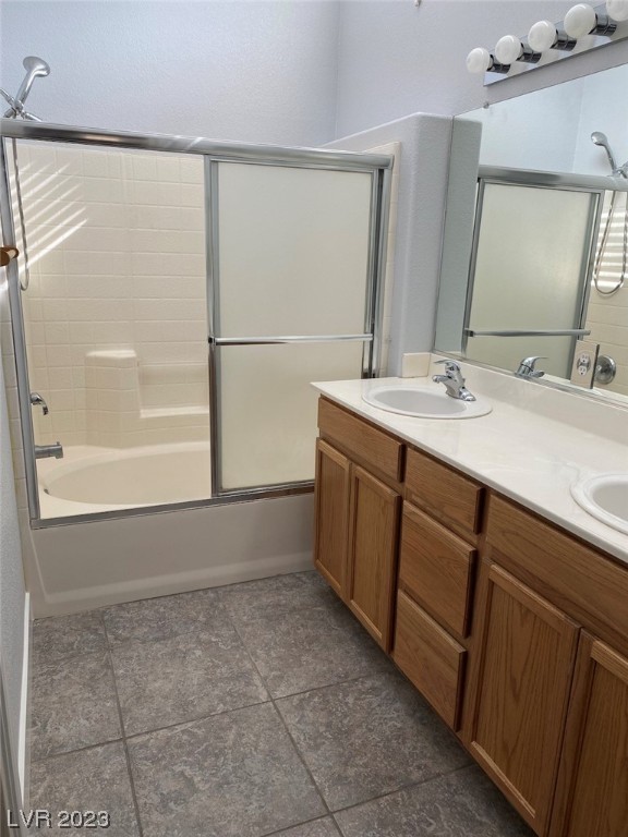 Bathroom with a tub, sliding glass shower doors, and a double-sink wood vanity.
