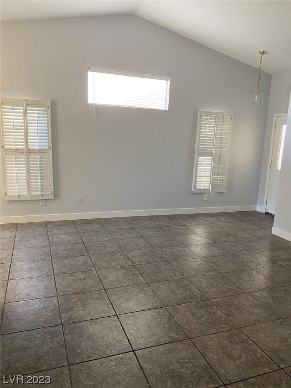 Empty tiled living area with shuttered windows and a glass pendant light.