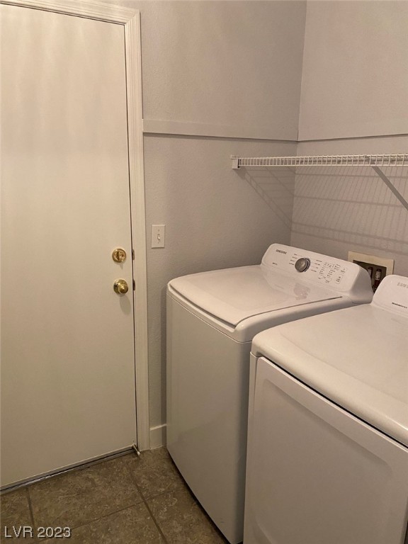 Laundry room with white washer and dryer beneath a wire shelf.