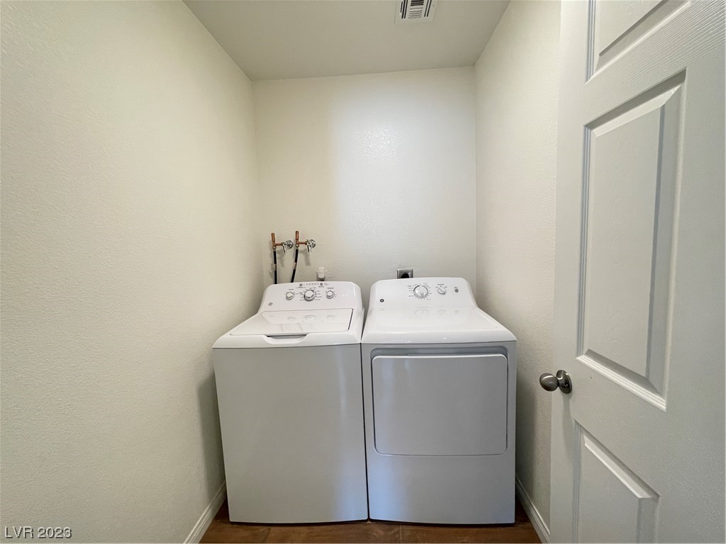Laundry room with a top-loading washer and front-loading dryer side by side.