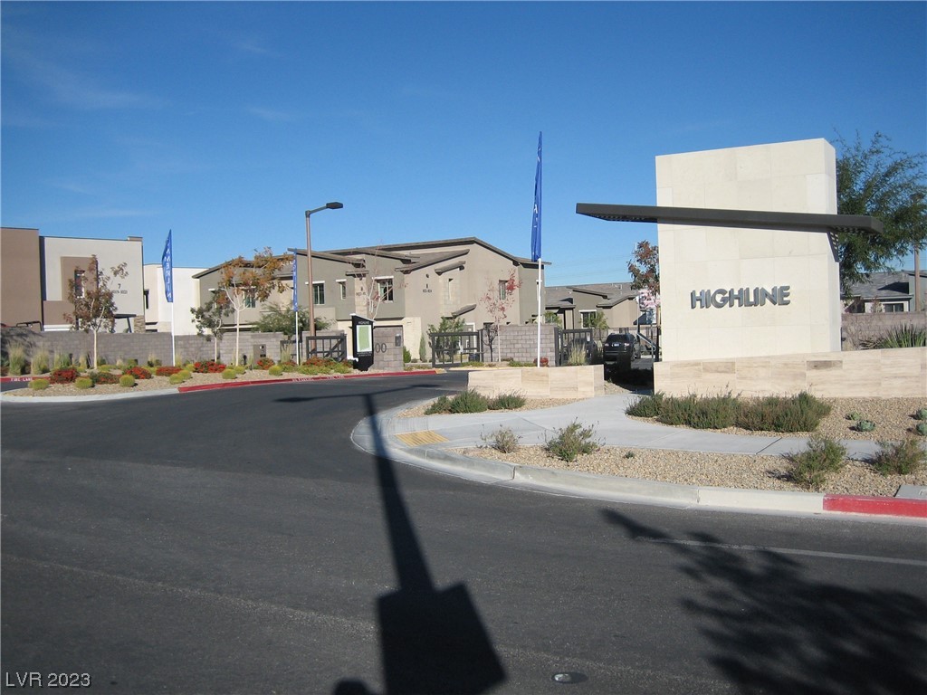Highline community entrance with a large stone sign and modern homes behind it.
