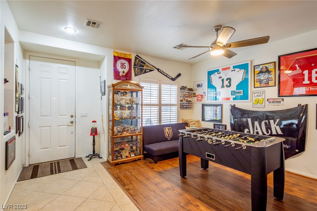 Game room with a foosball table, sports memorabilia display cabinet, and framed jerseys.