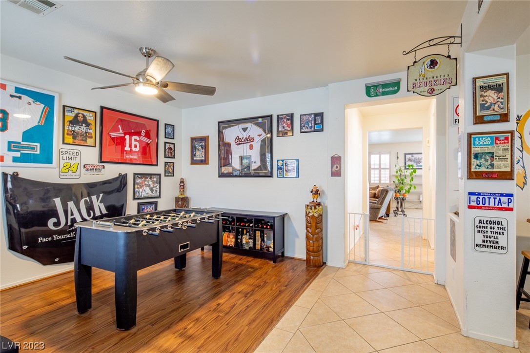 Furnished game room with a foosball table, sports memorabilia, and a tiled entryway.