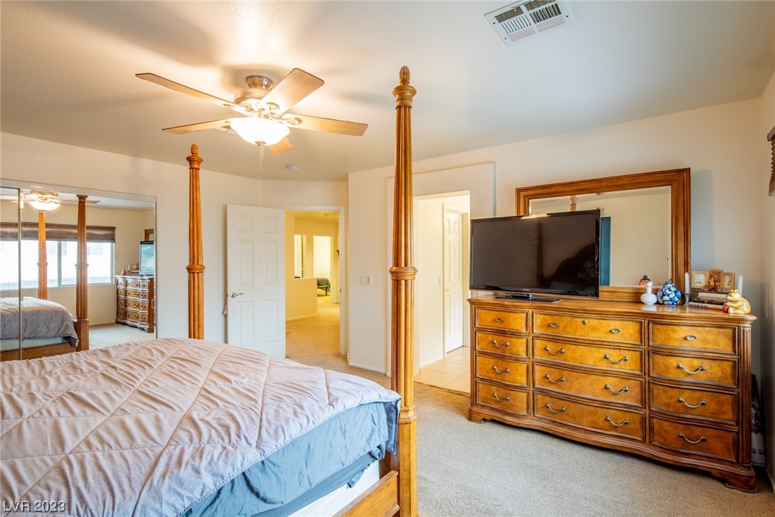 Bedroom with a four-poster wooden bed and a television on a large dresser.
