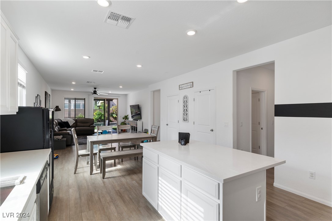 Open kitchen with a large white island, adjoining dining area, and living room.