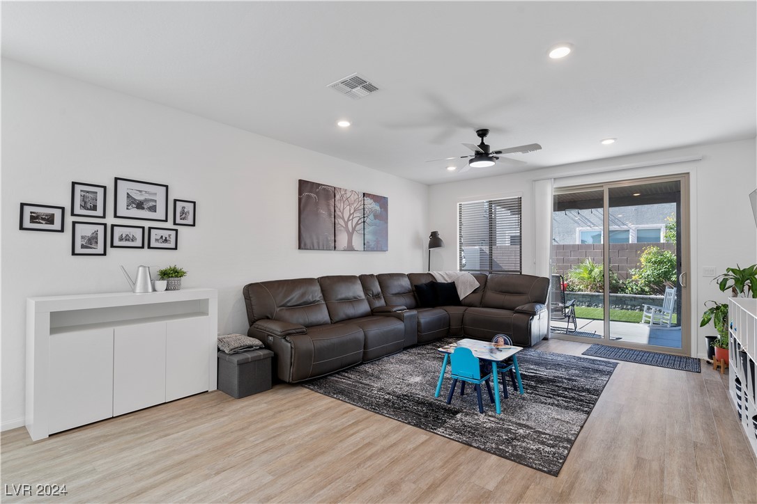 Living room with a dark sectional, patterned rug, and sliding glass doors to a patio.