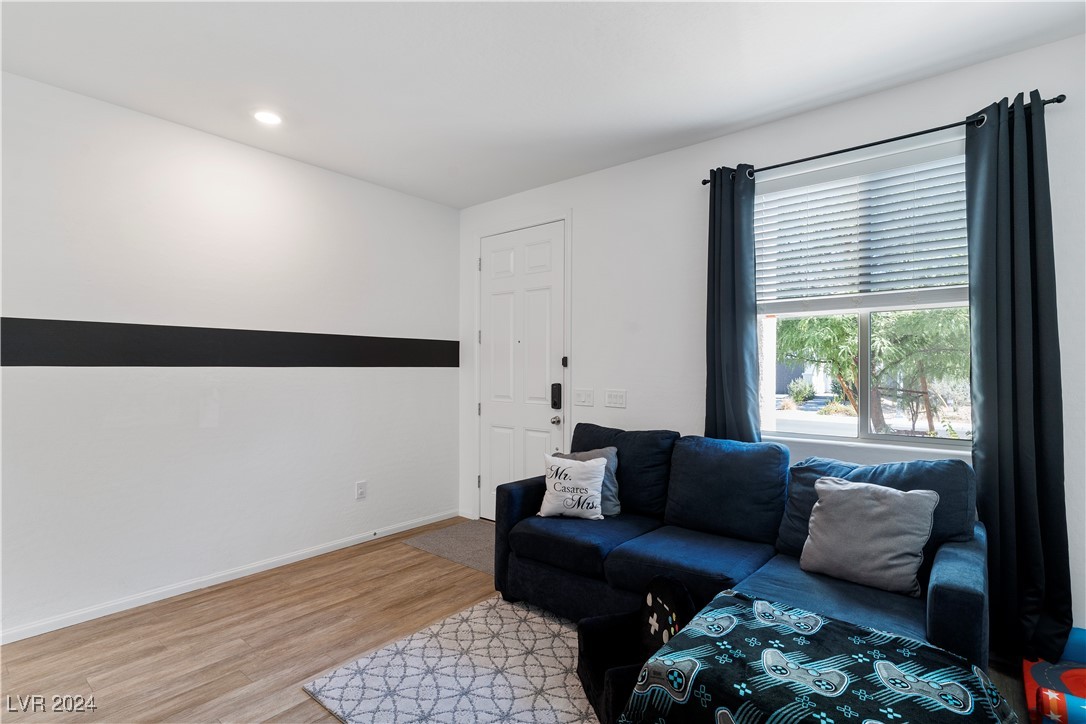 Living room with a dark blue sectional, patterned rug, and window framed by dark curtains.