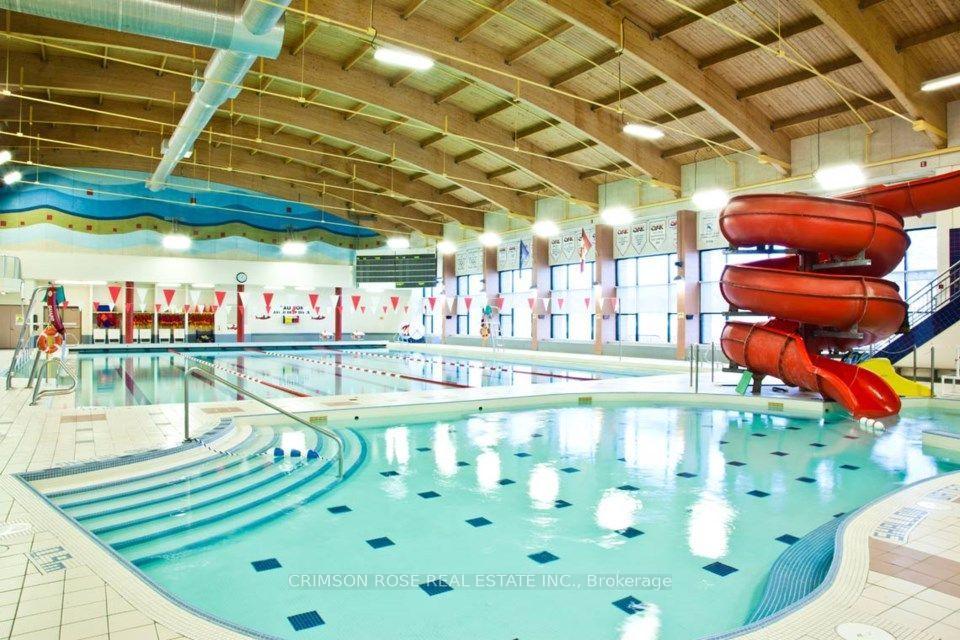 Indoor swimming pool with lap lanes and a large red twisting water slide.