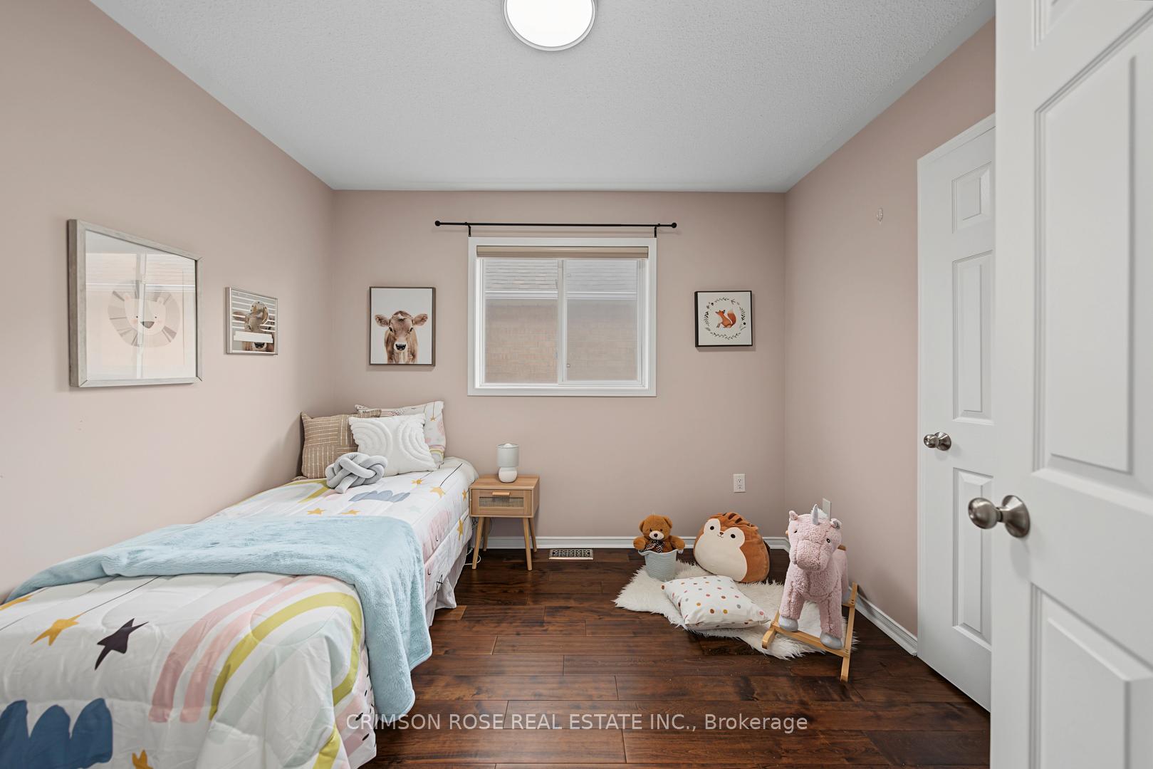 Furnished child's bedroom with colorful star bedding, plush toys, and framed animal prints.