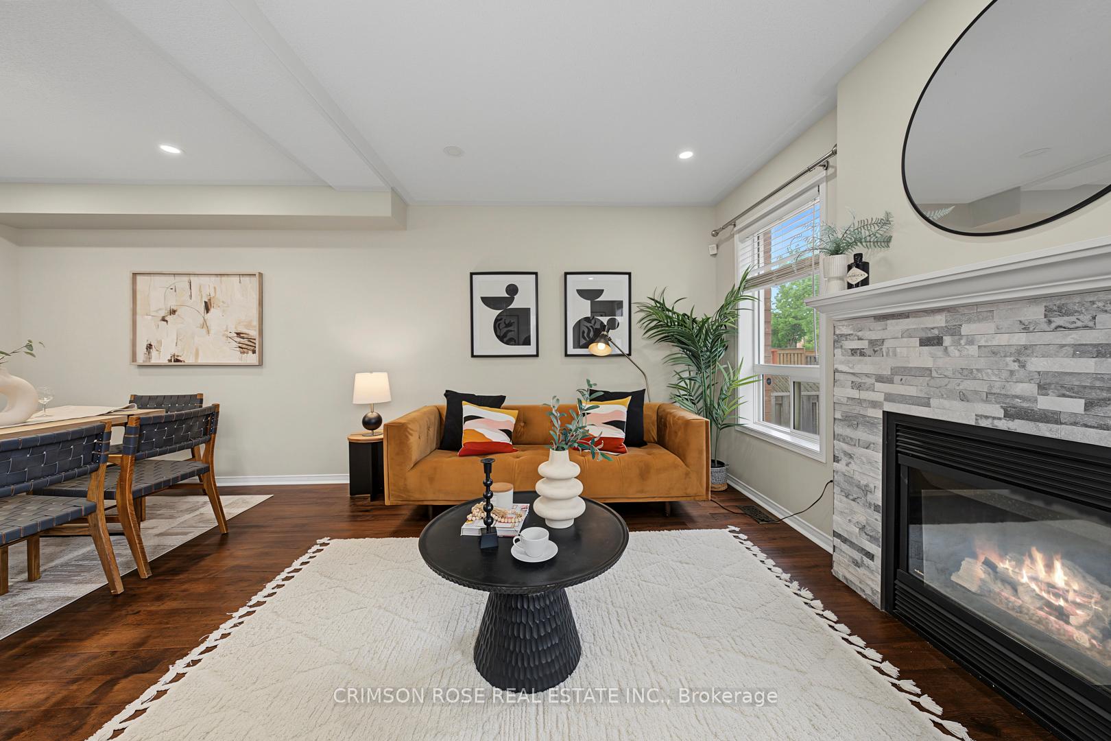 Living room with a mustard sofa, round coffee table, white rug, and stone fireplace.